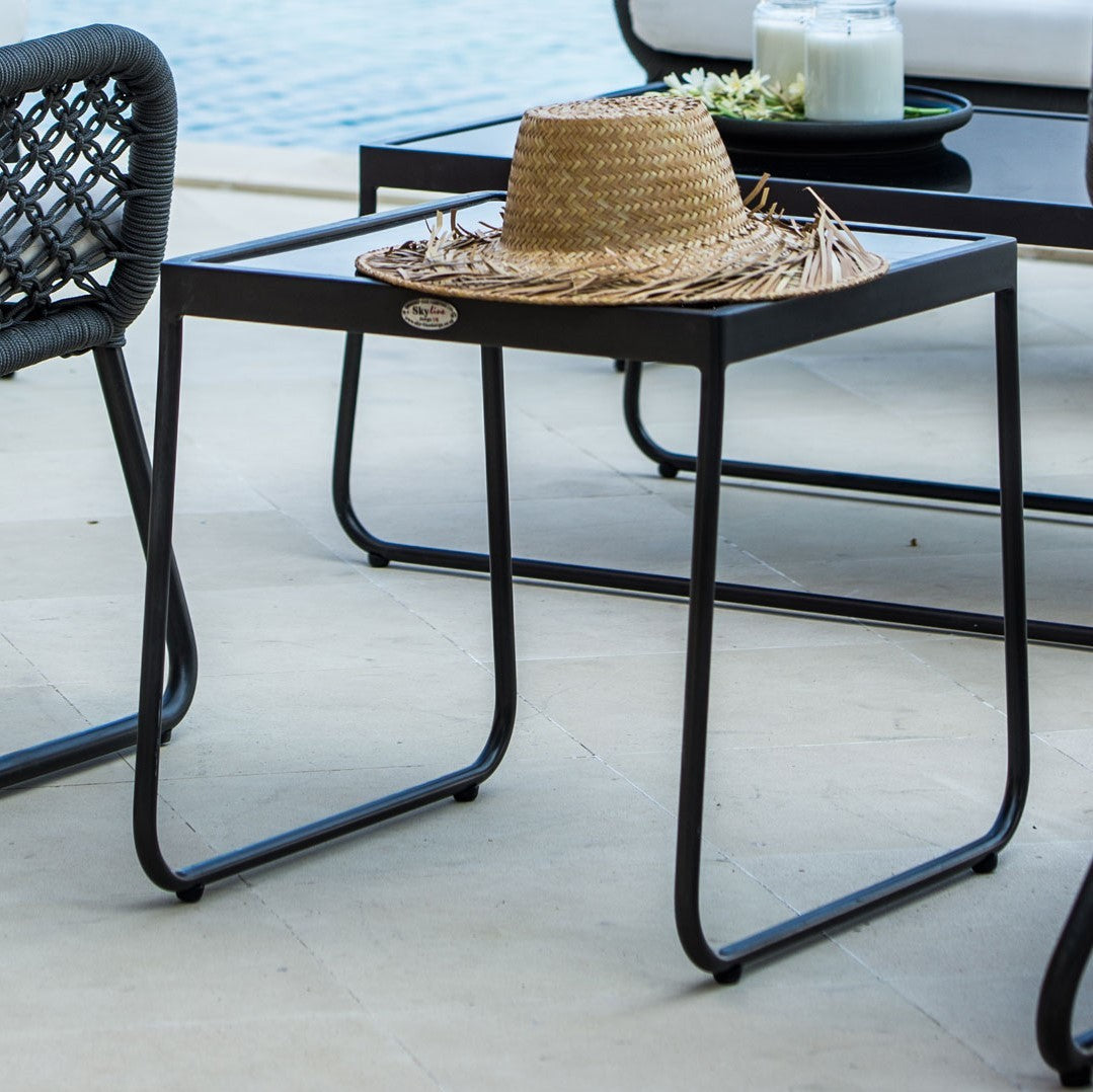 a black wicker side table with a hat