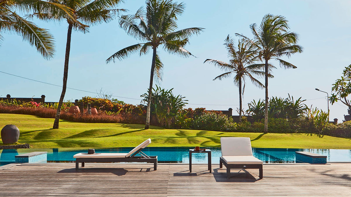 a wooden deck with lounge chairs and a pool