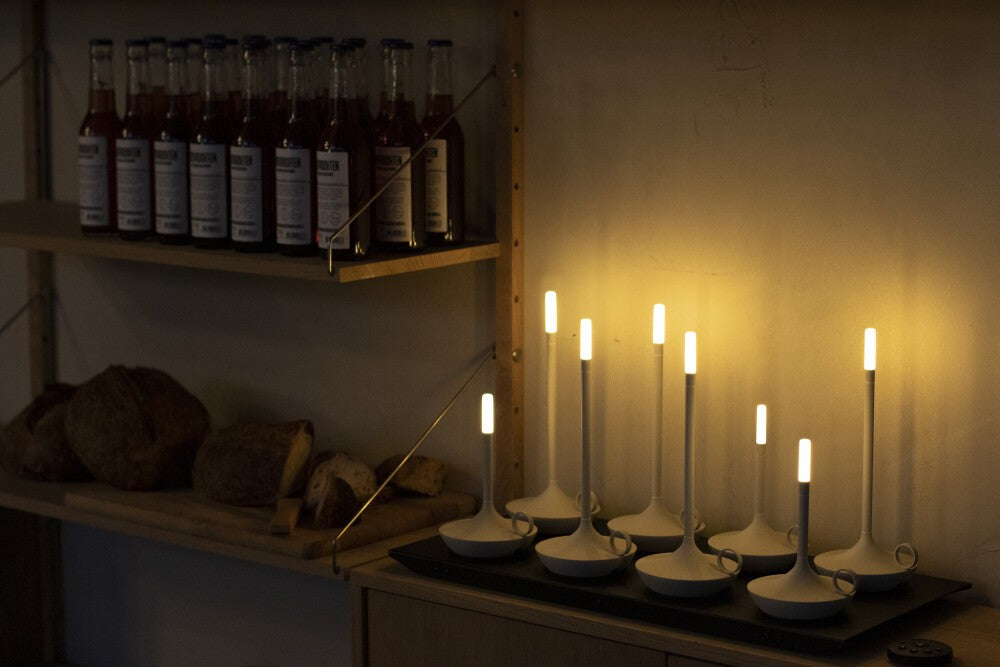 8-piece charging tray with several Wick Pro table lamps lit in a shaded room