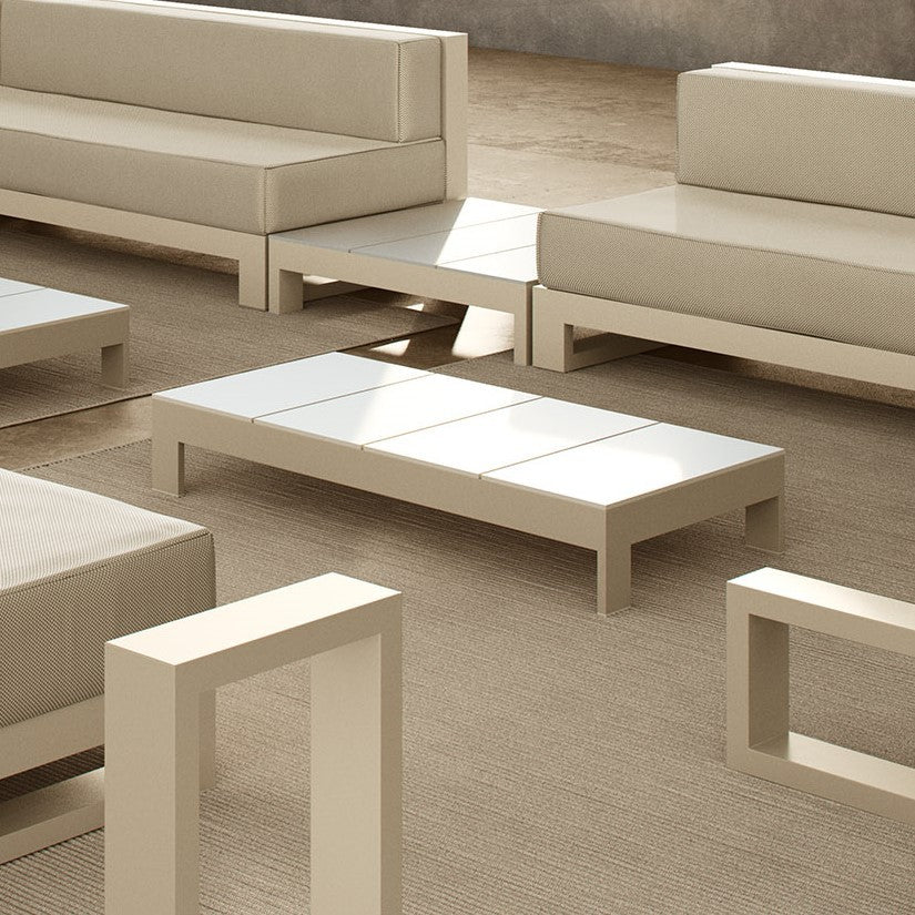 outdoor terrace furnished in beige and white tones, with two sofas, two coffee tables, a side table