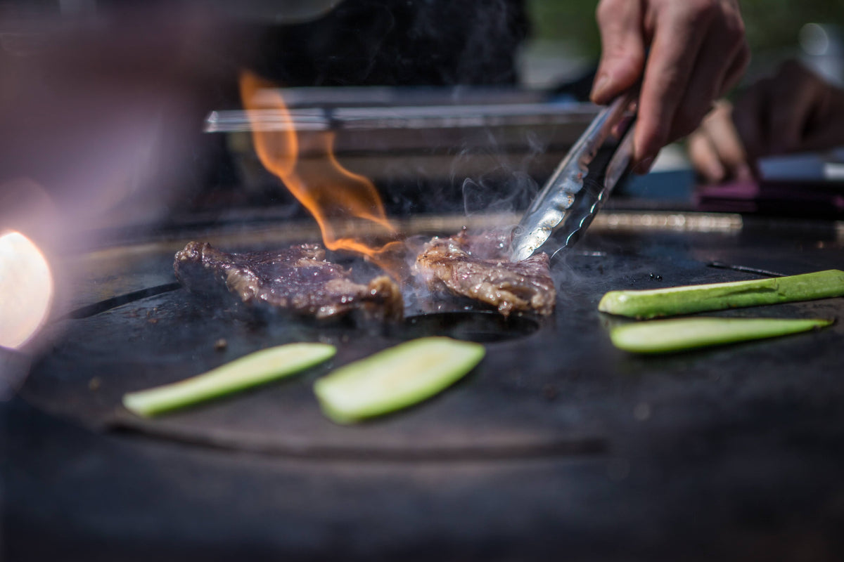 Cooking vegetables and meat on the Vulx Fusion High Gas 2-in-1 Barbecue Table for catering events