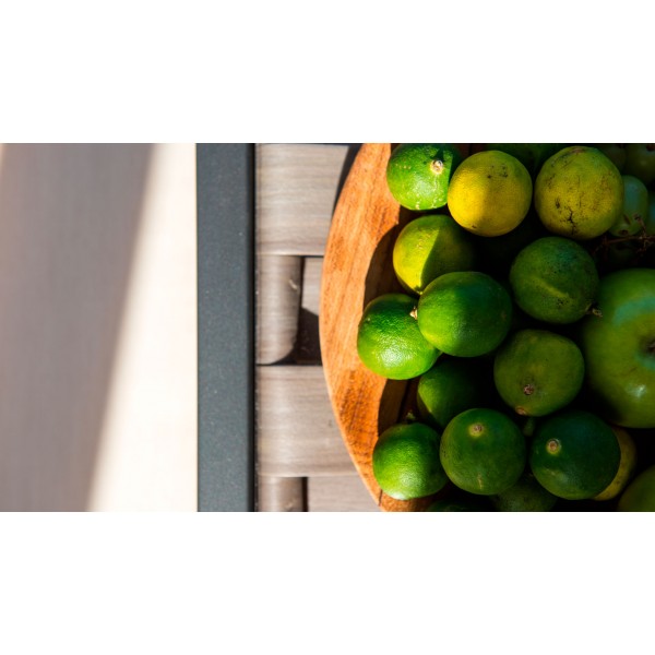 a bowl of limes on a wooden table