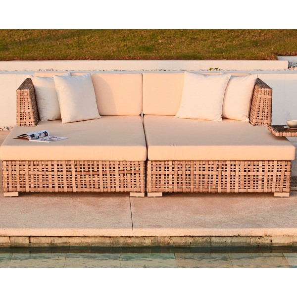 a wicker sofa next to a pool
