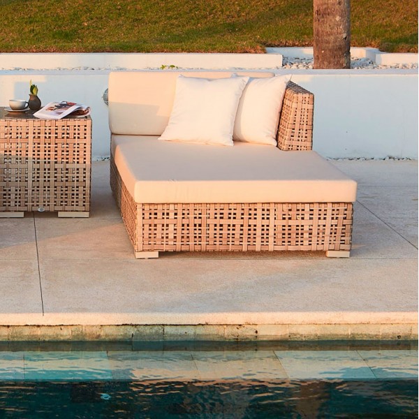 a set of wicker furniture next to a pool