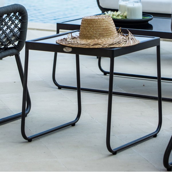 a black wicker side table with a hat