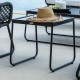 a black wicker side table with a hat