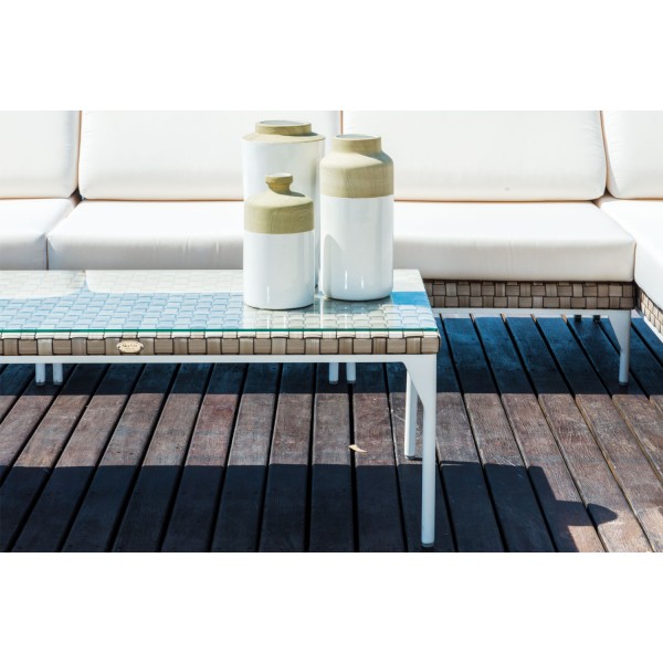 a white couch and vases on a wooden deck