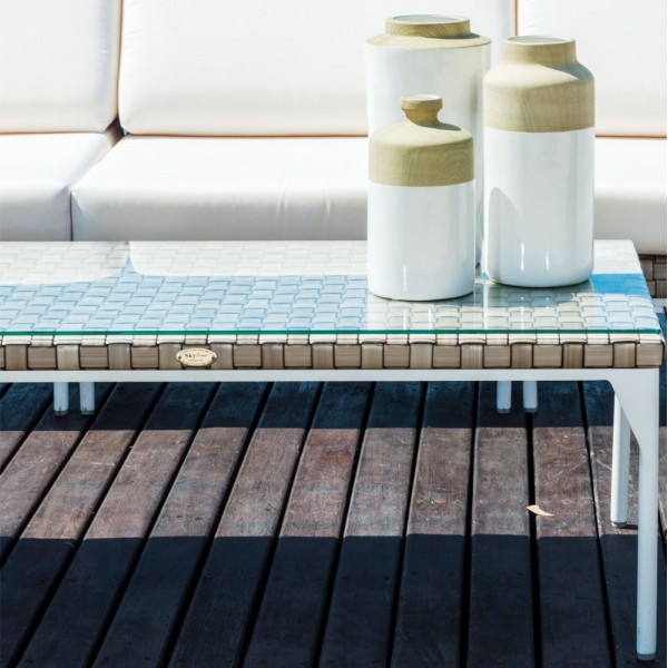 a white couch and vases on a wooden deck