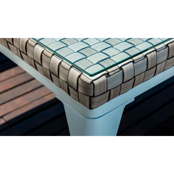 une table en osier avec un plateau en verre