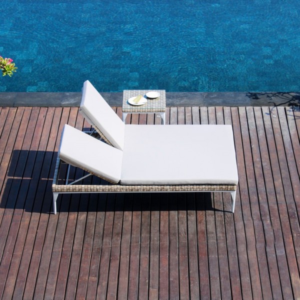 a lounge chair on a wooden deck next to a pool