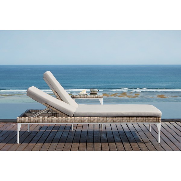 a lounge chair on a deck overlooking the ocean