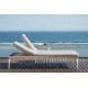 a lounge chair on a deck overlooking the ocean