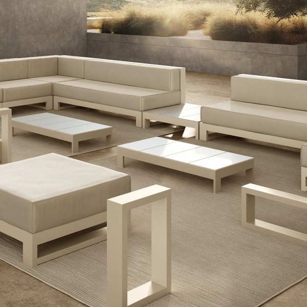 outdoor terrace furnished in beige and white tones, with two sofas, two coffee tables, a side table
