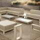 terrasse extérieure meublée dans des tons beige et blanc, dotée de deux canapés, deux tables basses, une table d'appoint