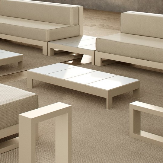outdoor terrace furnished in beige and white tones, with two sofas, two coffee tables, a side table