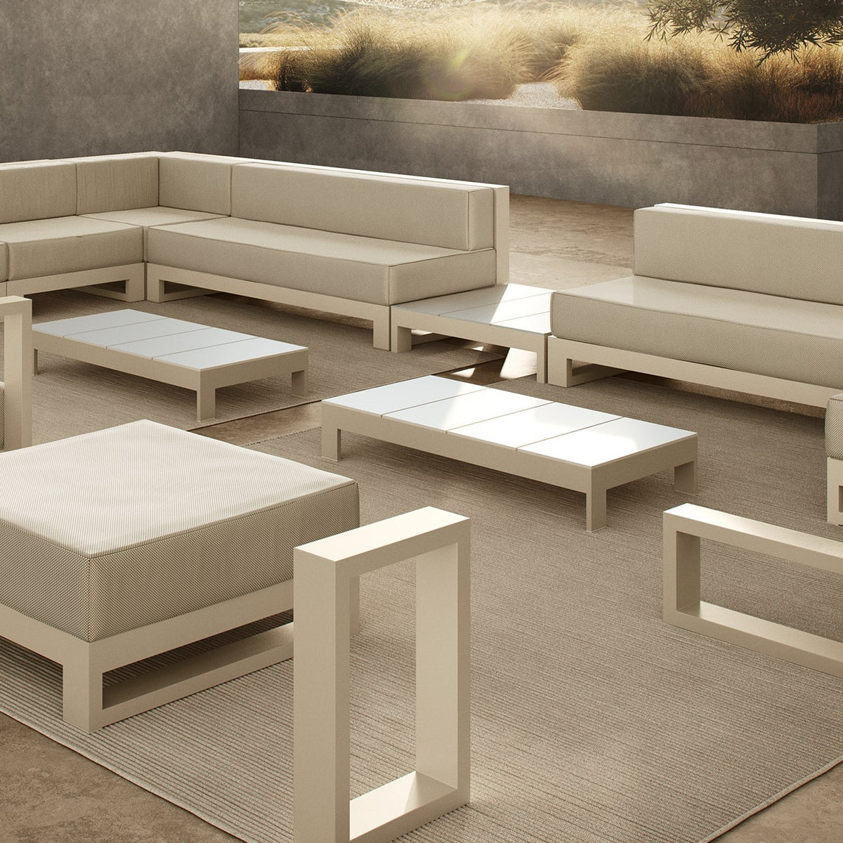 terrasse extérieure meublée dans des tons beige et blanc, dotée de deux canapés, deux tables basses, une table d'appoint