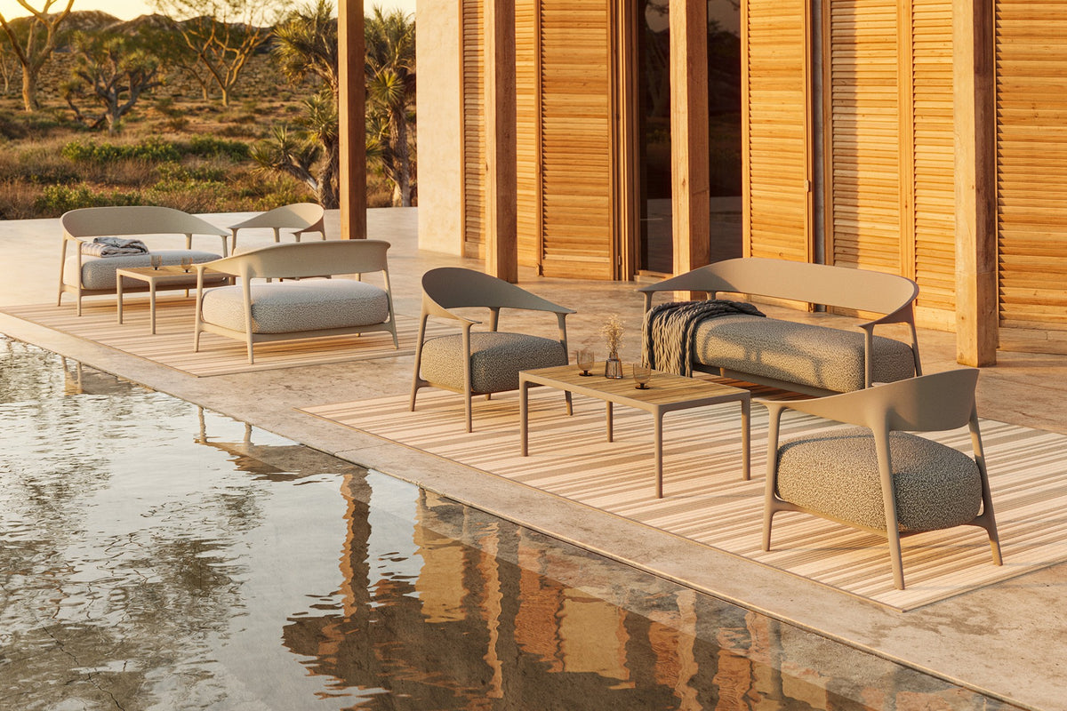 sofa, chairs, and tables for indoor and outdoor use by Vondom on a hotel terrace by the pool