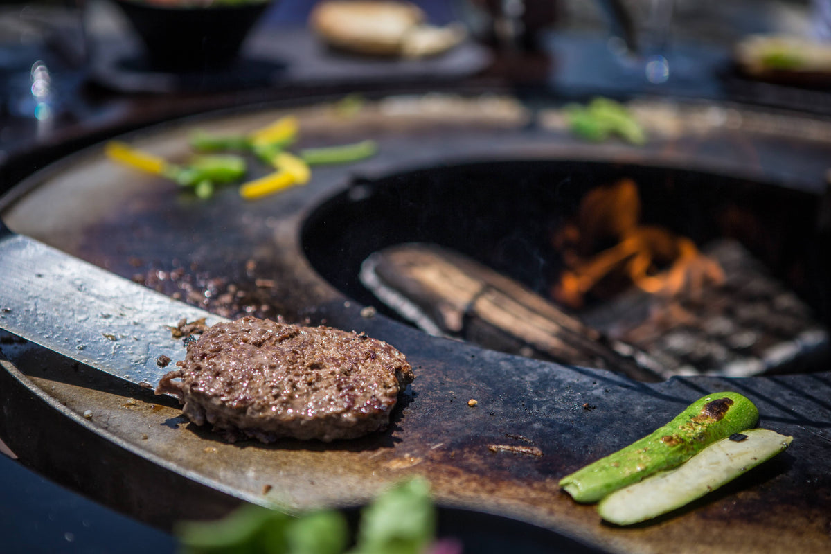 Cooking meat and vegetables on the plancha of the FUSION HIGH BOIS de VULX